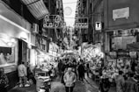 A lively street market in Naples with colorful stalls and locals shopping