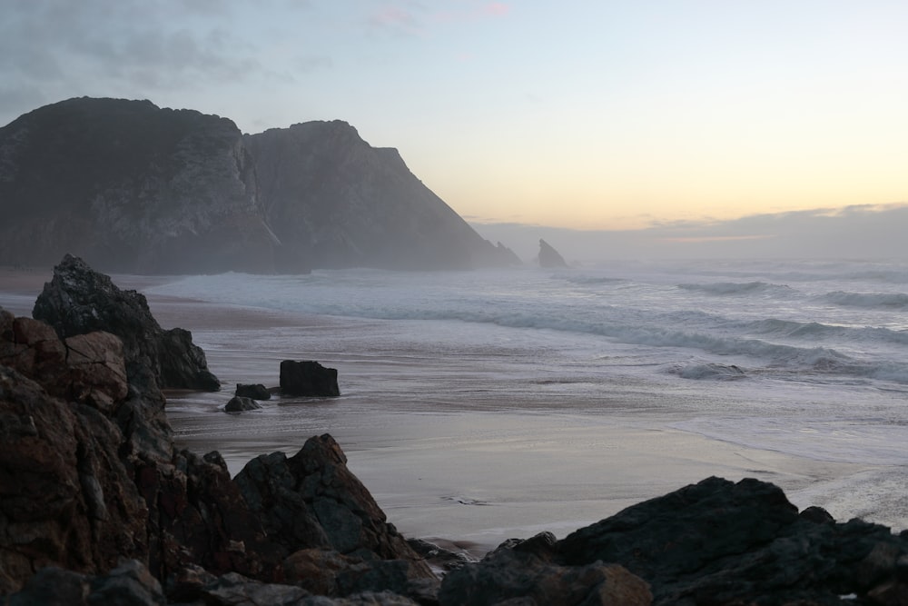 sea waves crashing on shore during daytime