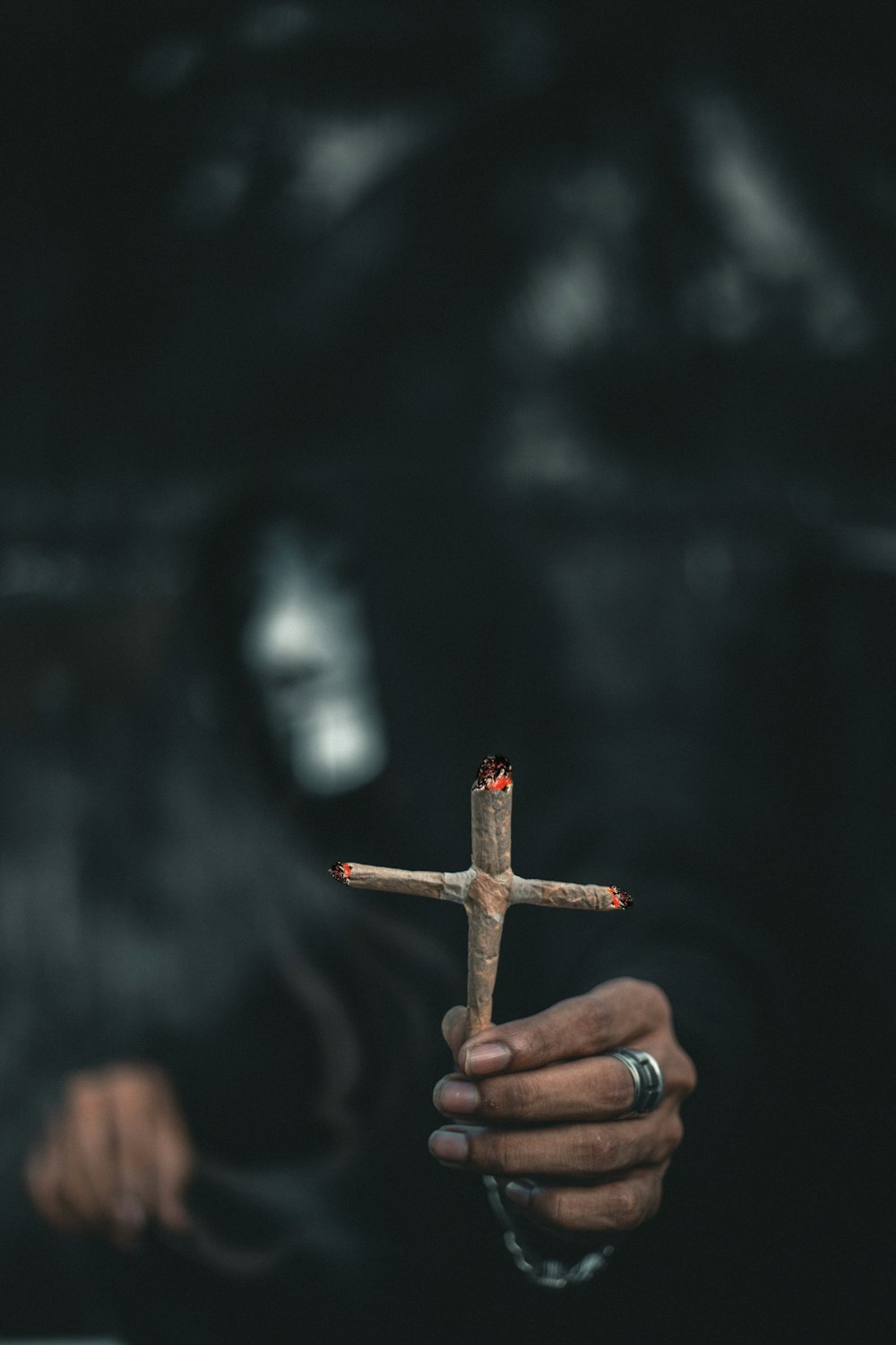 Persona sosteniendo una cruz de madera marrón