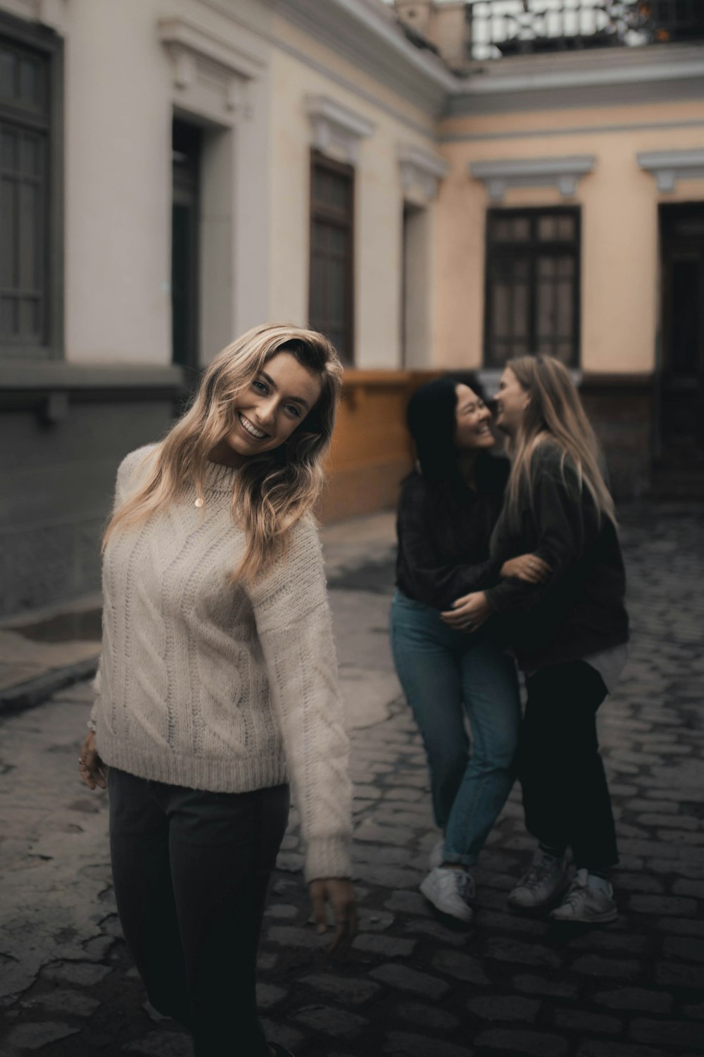 woman in white sweater and black pants wearing black framed eyeglasses