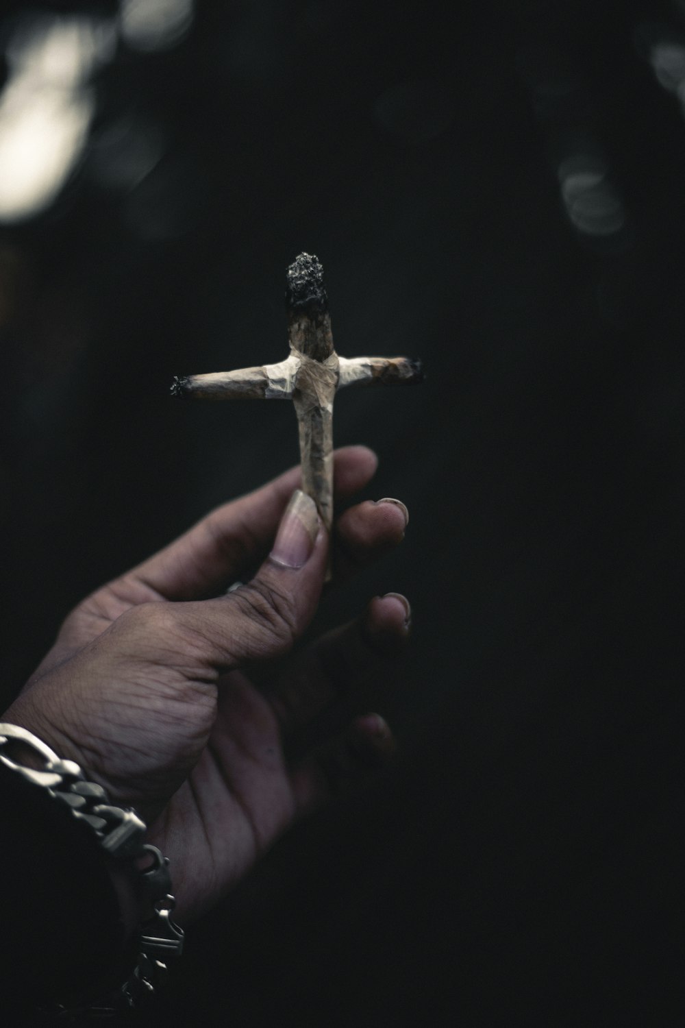 person holding brown wooden cross
