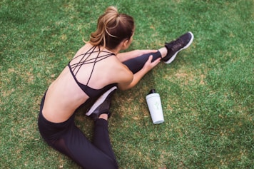 woman in black lingerie holding white bottle