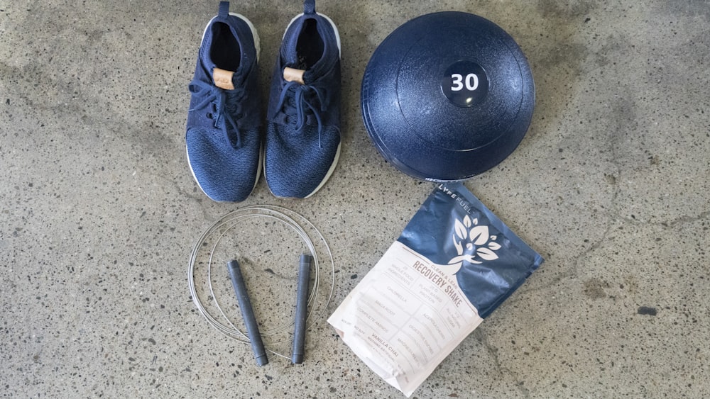 Zapatillas deportivas Nike azules y blancas junto a una pelota de ejercicio redonda negra