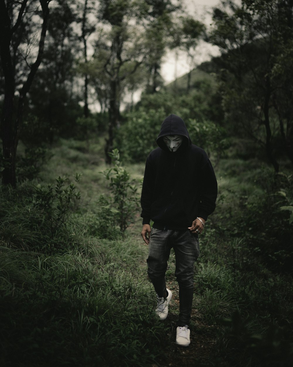 man in black hoodie standing on green grass field during daytime