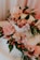 A beautifully decorated cake with floral designs on a pastel pink background.