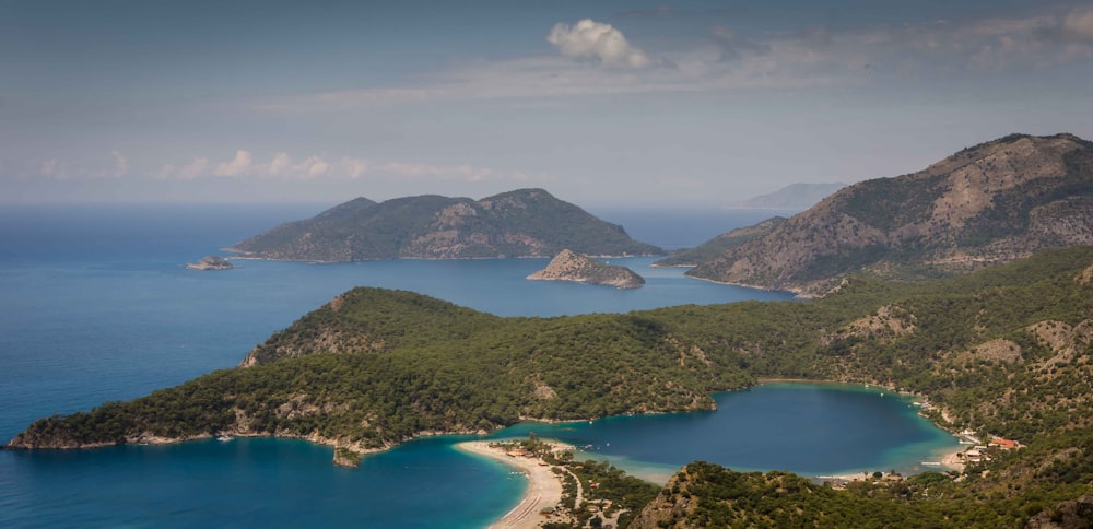 isola verde nel mezzo del mare blu sotto il cielo blu e nuvole bianche durante il giorno