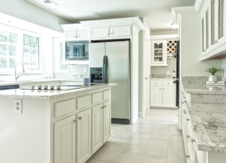 white wooden kitchen cabinet near white wooden door