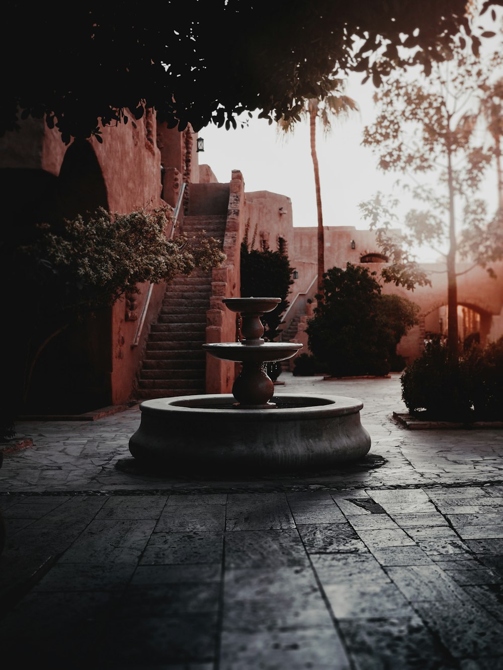 brown concrete fountain near brown concrete building during daytime