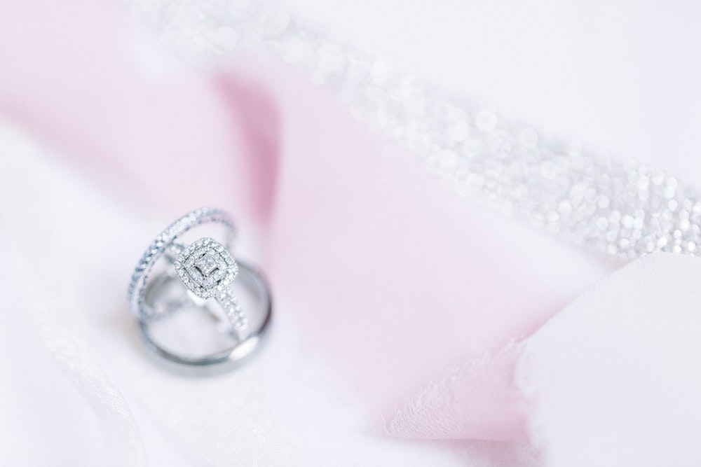 silver diamond ring on white textile