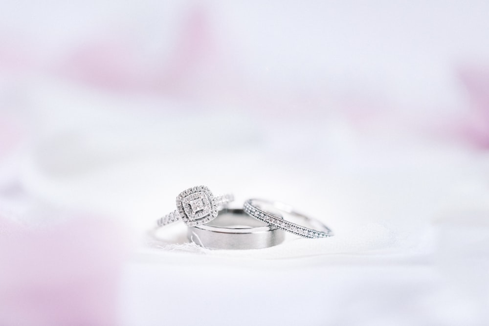 Silberner diamantbesetzter Ring auf weißer Oberfläche