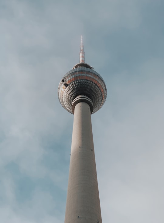 low angle photography of gray tower under white clouds during daytime in Fernsehturm Berlin Germany