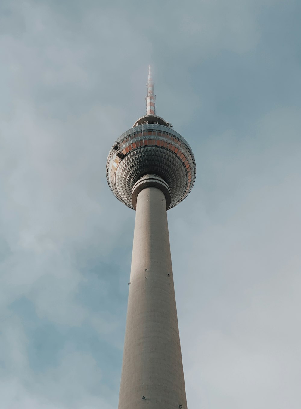 low angle photography of gray tower under white clouds during daytime