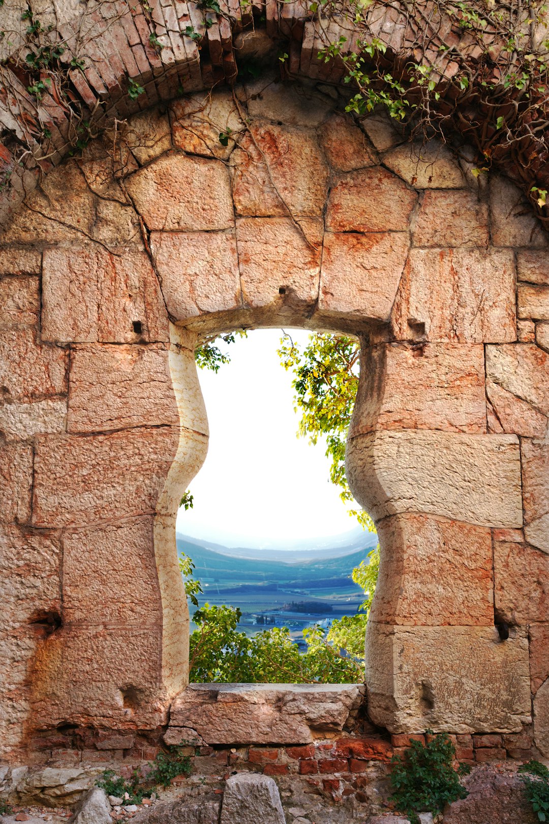 brown concrete arch near green trees during daytime