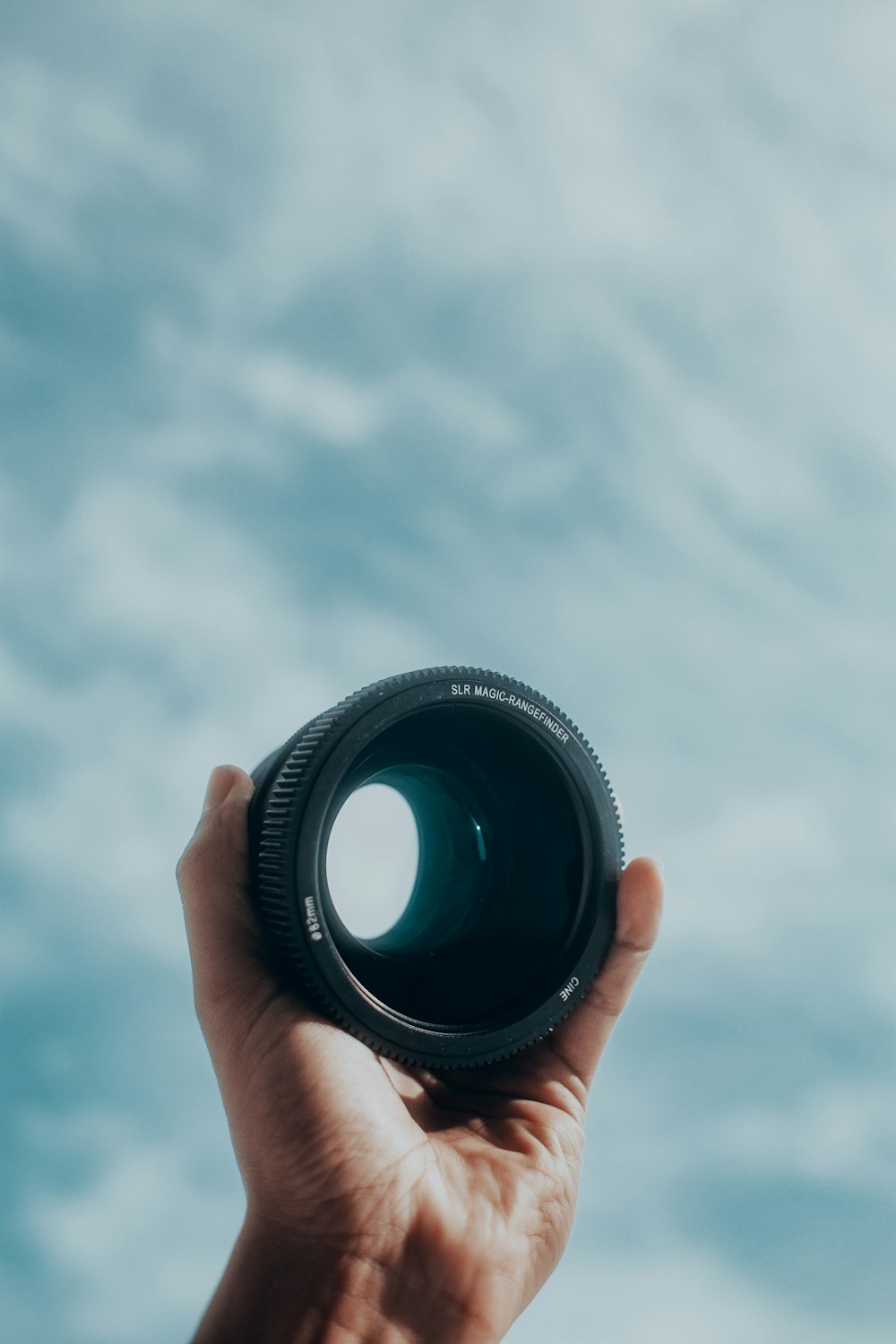 person holding black camera lens