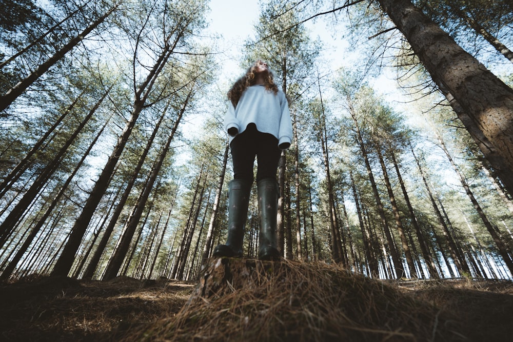 woman in white long sleeve shirt and black pants standing on brown dried grass during daytime