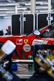 A sleek Ferrari serviced by experts in a modern workshop.