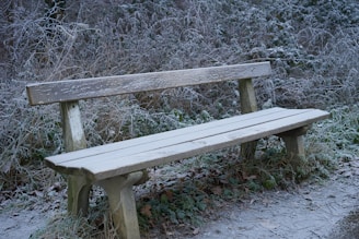 Foldable snow-resistant bench dusted with fresh snow in a cozy backyard setting.