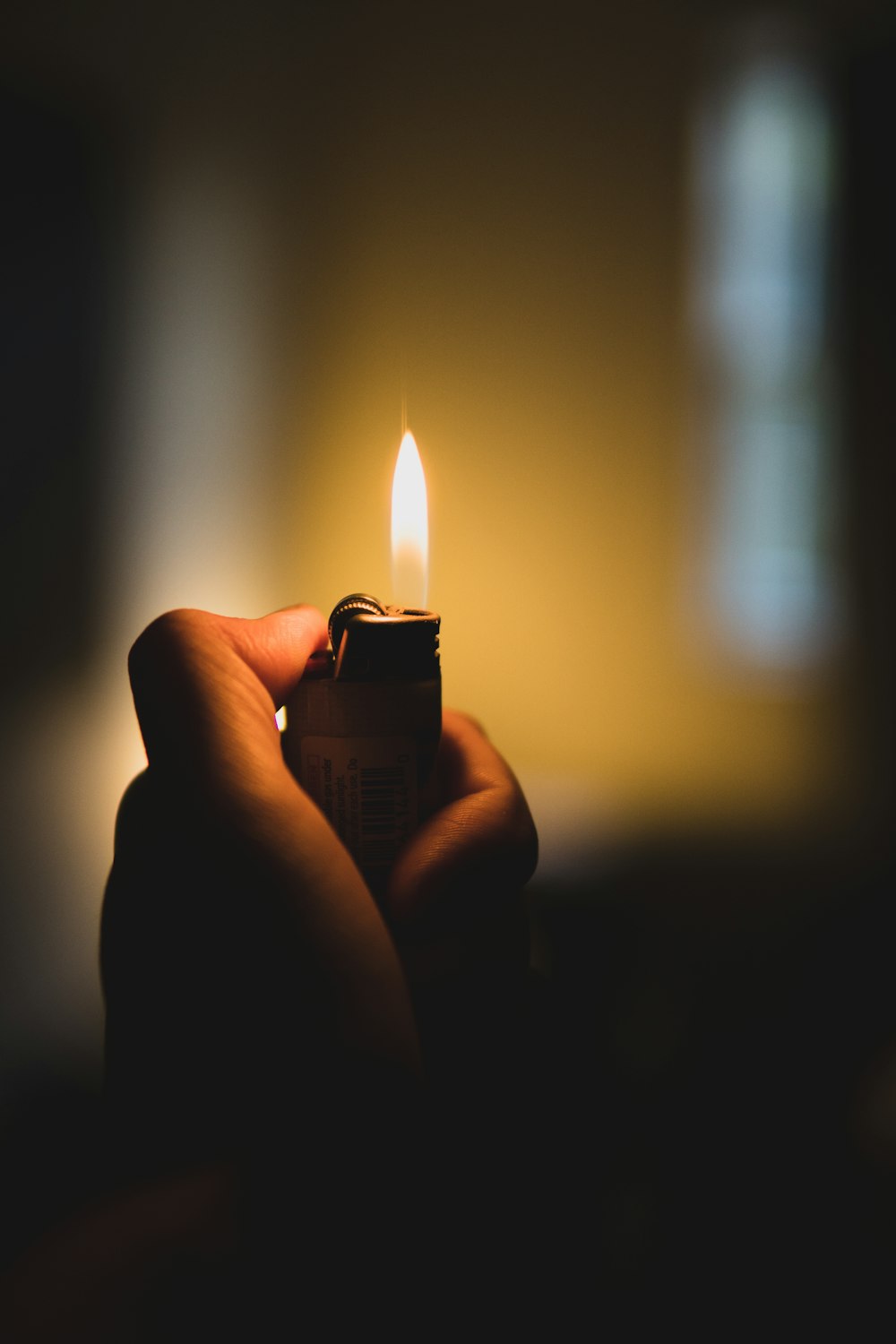 person holding lighter with yellow light