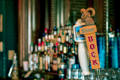 Close-up of sleek custom tap handles with vibrant branded menus on a mobile trailer.