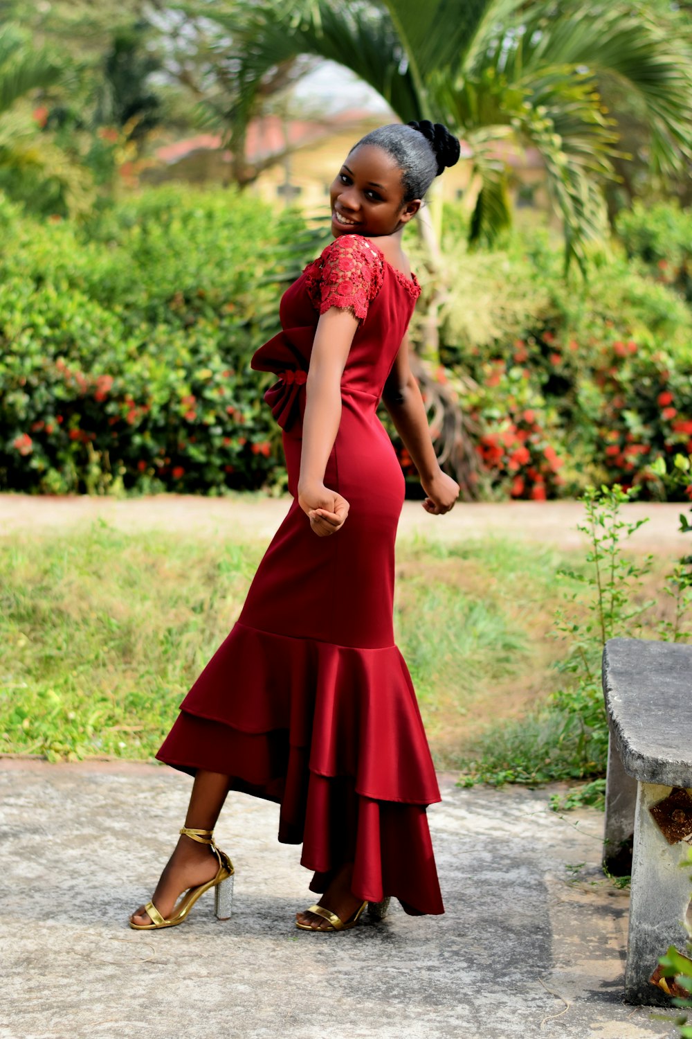 woman in red dress standing on gray concrete floor