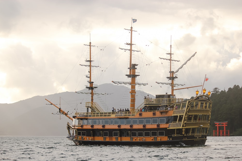 barco marrón en el mar bajo nubes blancas durante el día