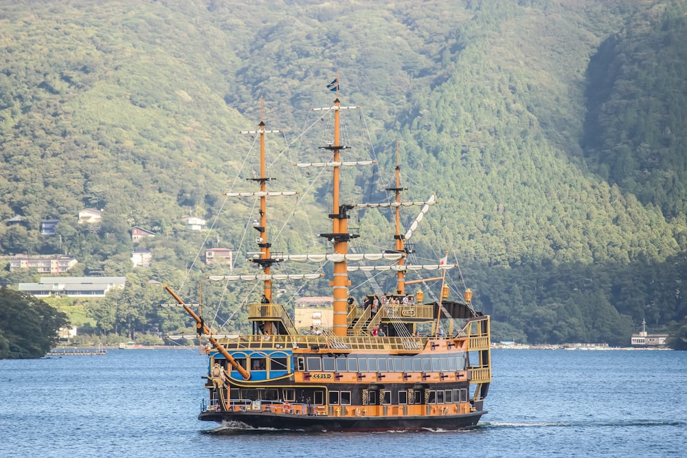 Barco marrón en el mar cerca de la montaña durante el día