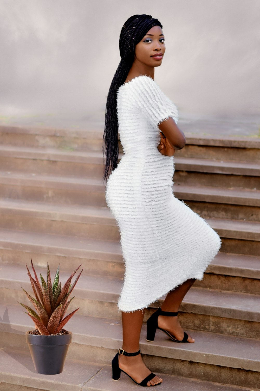 woman in white dress standing on brown wooden stairs