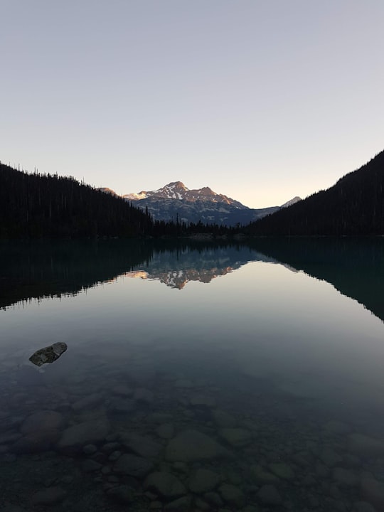 lake surrounded by green trees and mountains during daytime in Joffre Lakes Provincial Park Canada