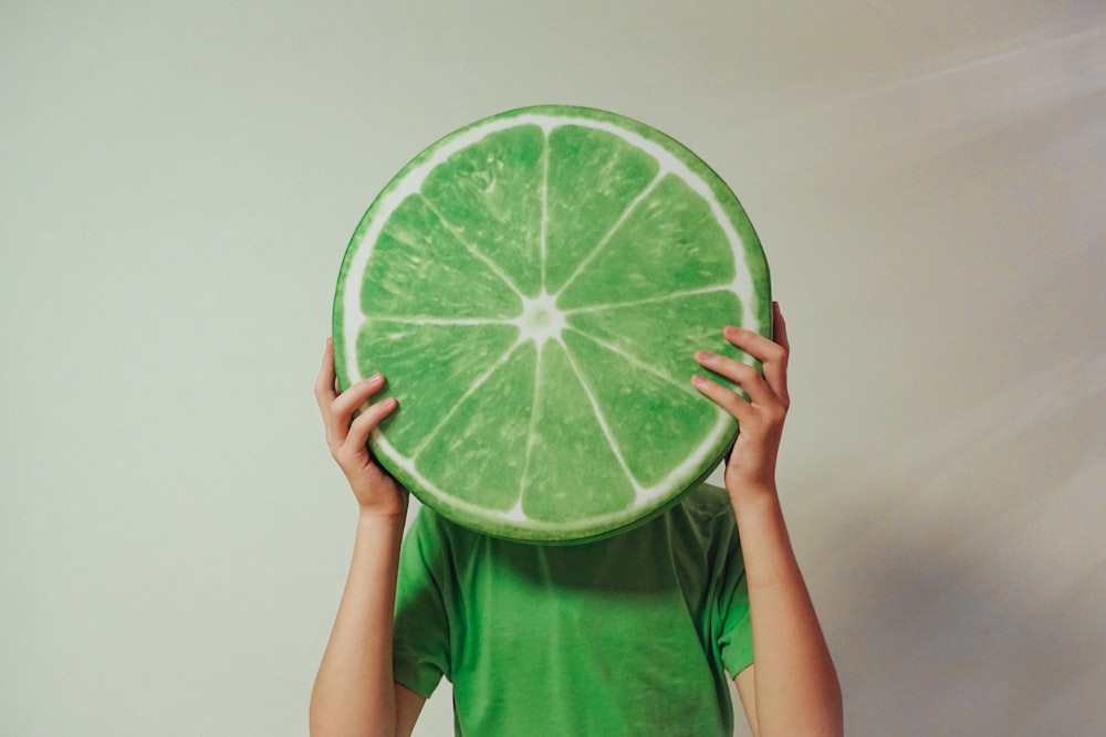 person holding sliced green watermelon