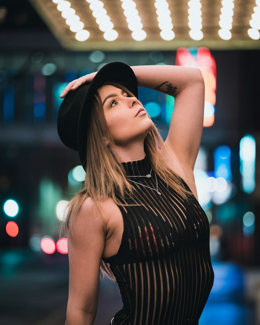 woman in black and white striped tank top wearing black hat