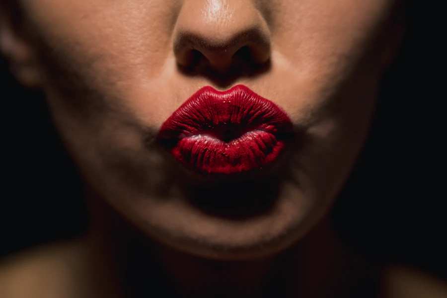 Close-up beauty portrait with red lipstick and dark lashes