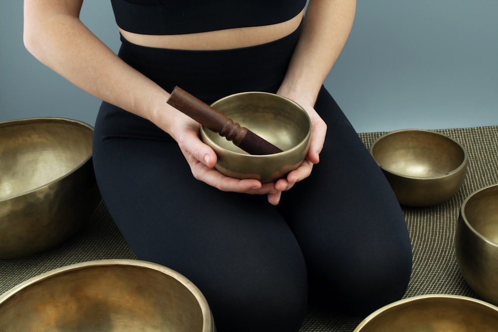 woman in black dress holding brown wooden mortar and pestle