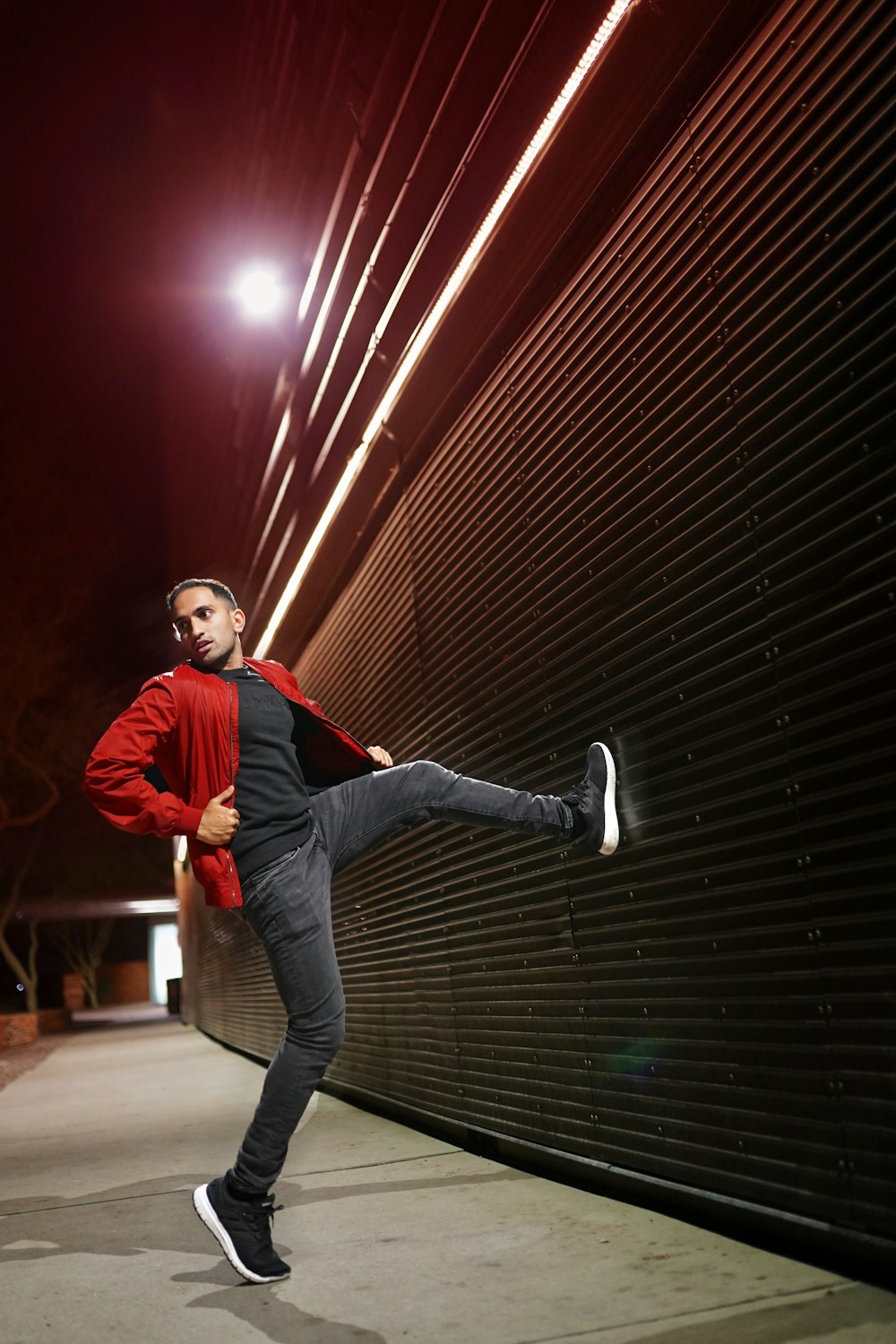 man in red jacket and gray denim jeans jumping