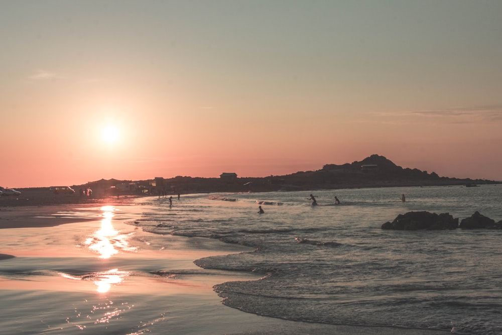 people on beach during sunset