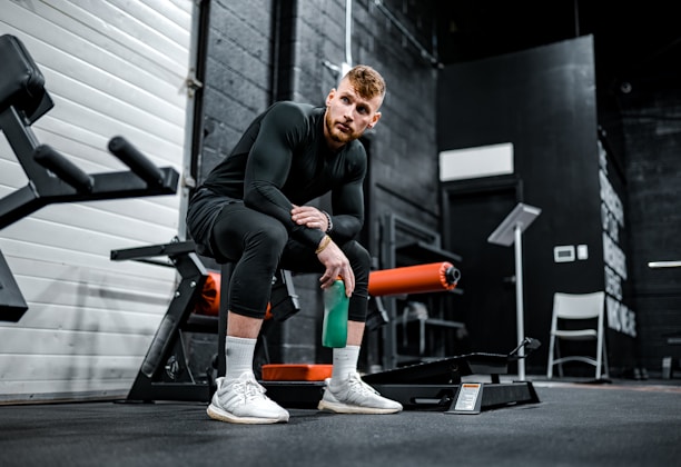 woman in black long sleeve shirt and black pants sitting on exercise equipment