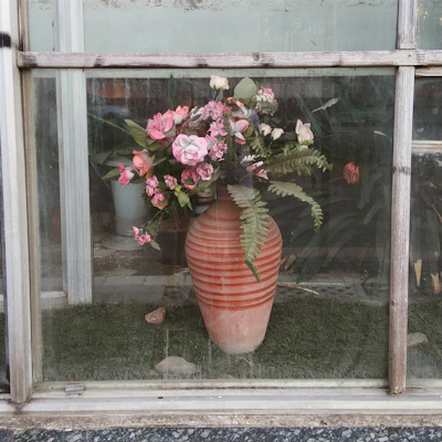 A classic ceramic flower vase with delicate floral patterns on a windowsill.