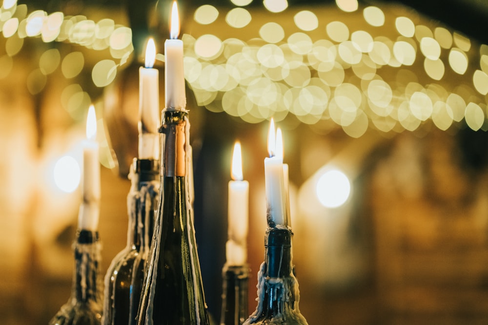 selective focus photography of candles on black bottles