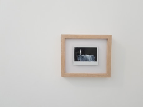 brown wooden framed photo on white wall