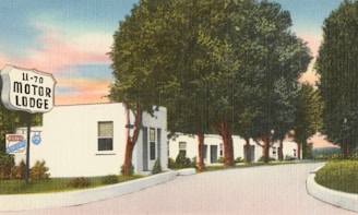 A vintage illustration of a motor lodge with a row of white buildings lined along a curved driveway. Large trees with deep green leaves arch over the drive, and a colorful sky with hints of pink and blue forms the backdrop. A prominently displayed sign reads '11-70 Motor Lodge'.