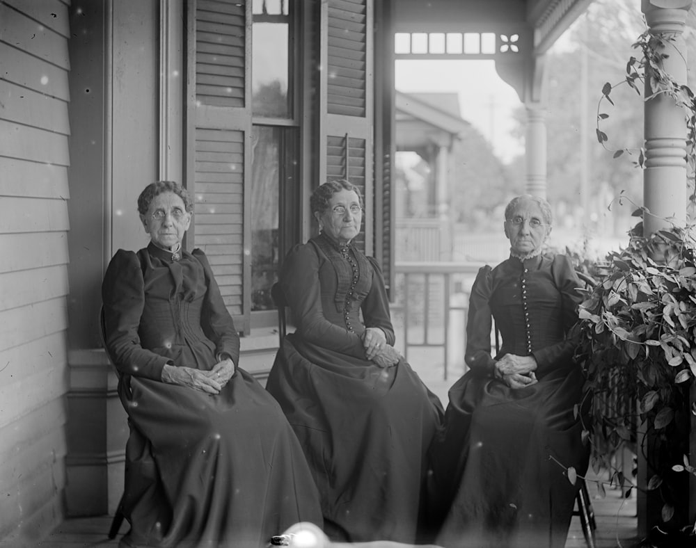 homme et femme assis sur une chaise dans la photographie en niveaux de gris