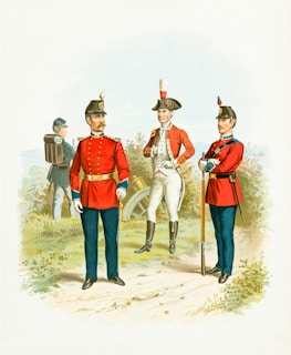 Two soldiers in red uniforms stand on a path, flanked by another soldier in white with a feathered hat. A fourth figure in blue, seen from behind, carries a backpack and is positioned near a cannon in the background. The scene is set outdoors, with foliage lining the path, suggesting a historical or military setting.