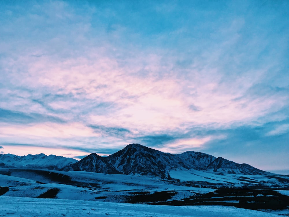 snow covered mountain under cloudy sky during daytime