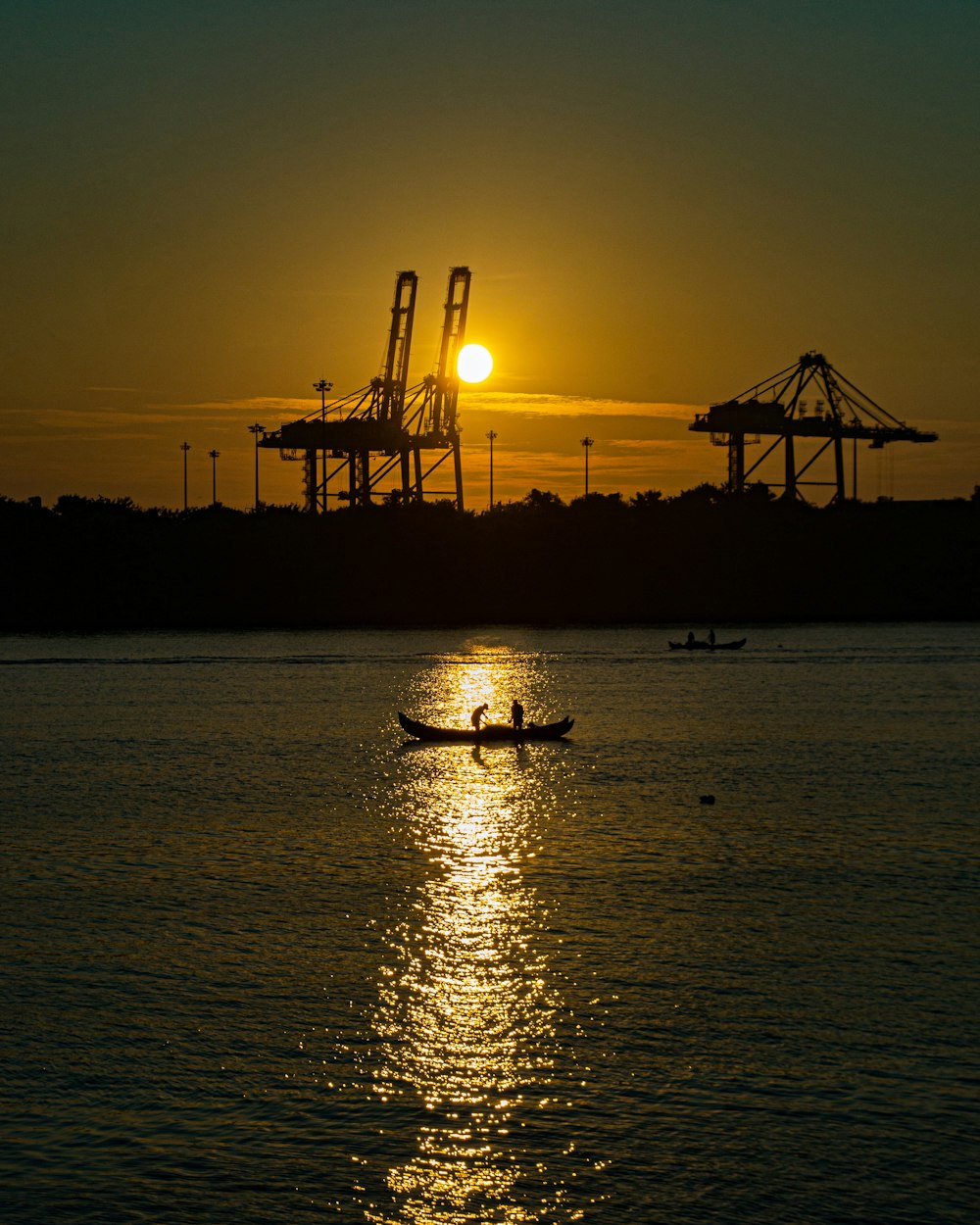 silhouette of boat on sea during sunset