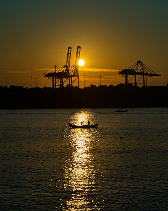 silhouette of boat on sea during sunset in Vallarpadam India