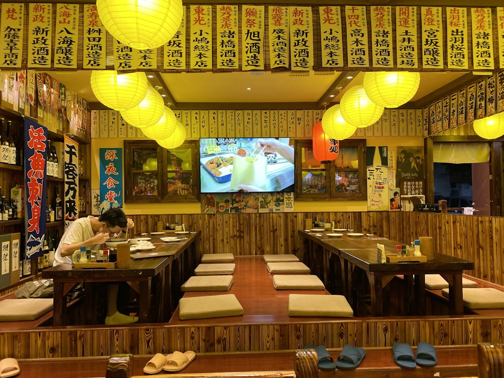 people sitting on brown wooden chairs inside restaurant