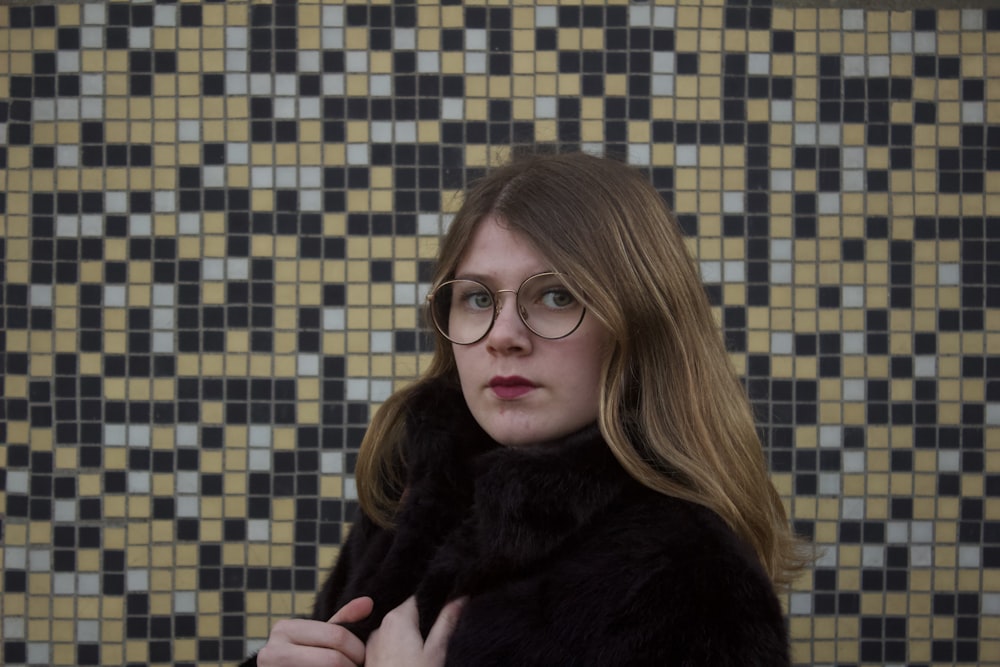 woman in black fur coat wearing black framed eyeglasses