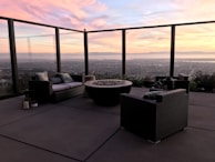 A terrace scene featuring weather-resistant sofas and a fire pit glowing warmly.