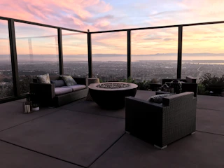 Wide shot of a spacious patio with integrated concrete seating and a central fire feature.