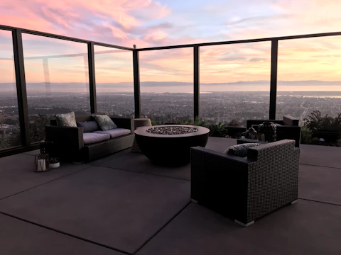 Wide shot of a spacious patio with integrated concrete seating and a central fire feature.