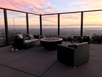 Outdoor patio with fire pit and seating overlooking rolling hills.